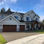 A mixture of Composite shingles and metal roofing on a beautiful custom home to illustrate architectural shingles vs composite shingles.